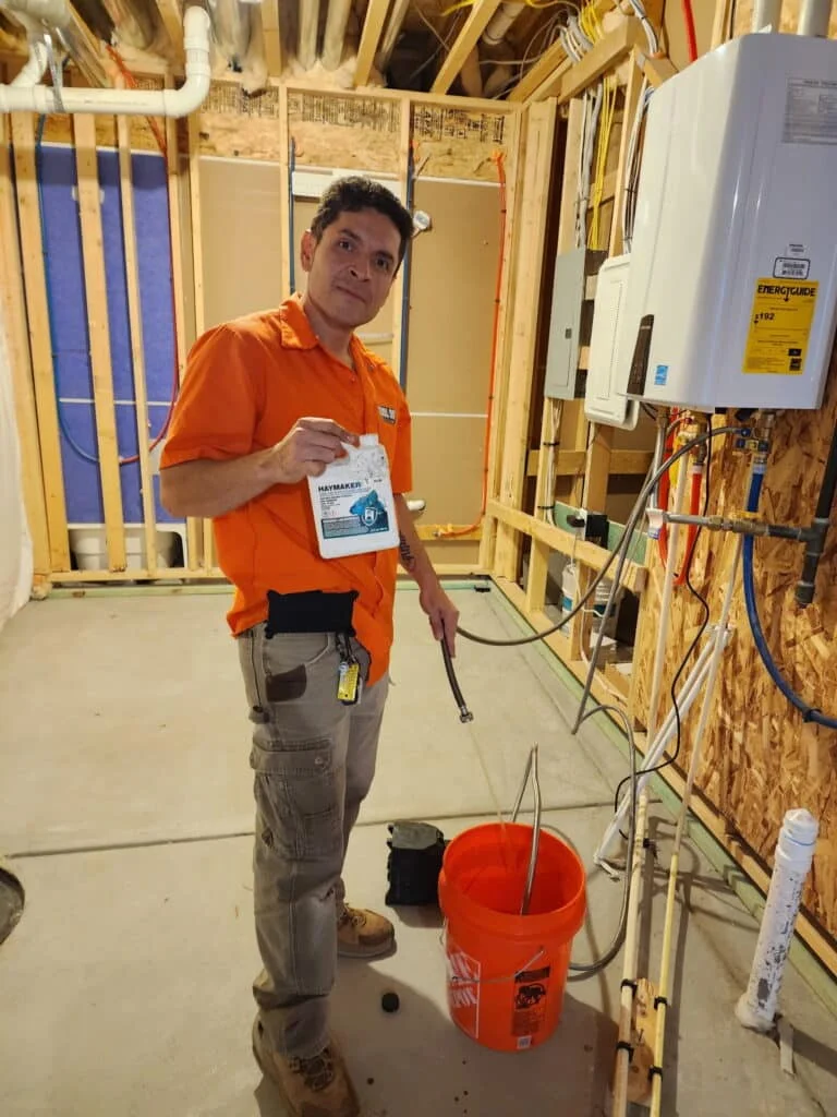 Vertical photograph of an indoor home heating unit showing complex ductwork connections in a residential basement